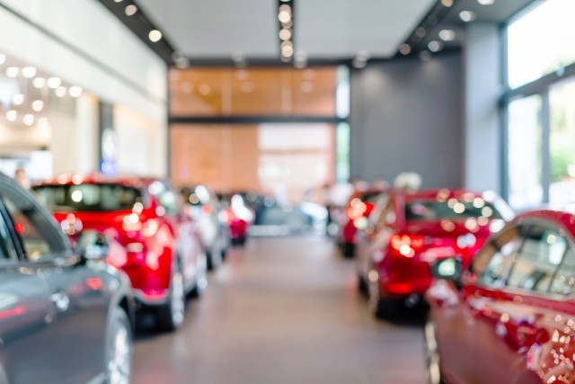 blured view of new modern vehicles in a showroom